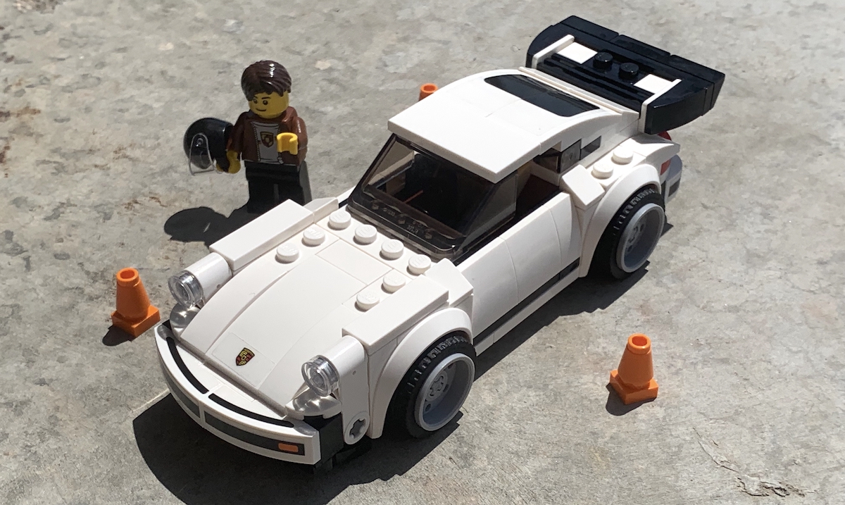 The entire Speed Champions '74 911 Turbo set 75895, including the three cones/pylons and minifigure dressed in Porsche apparel. This historic 911 looks great in white and the amount of ramps used to soften the profile is really clear at this angle.