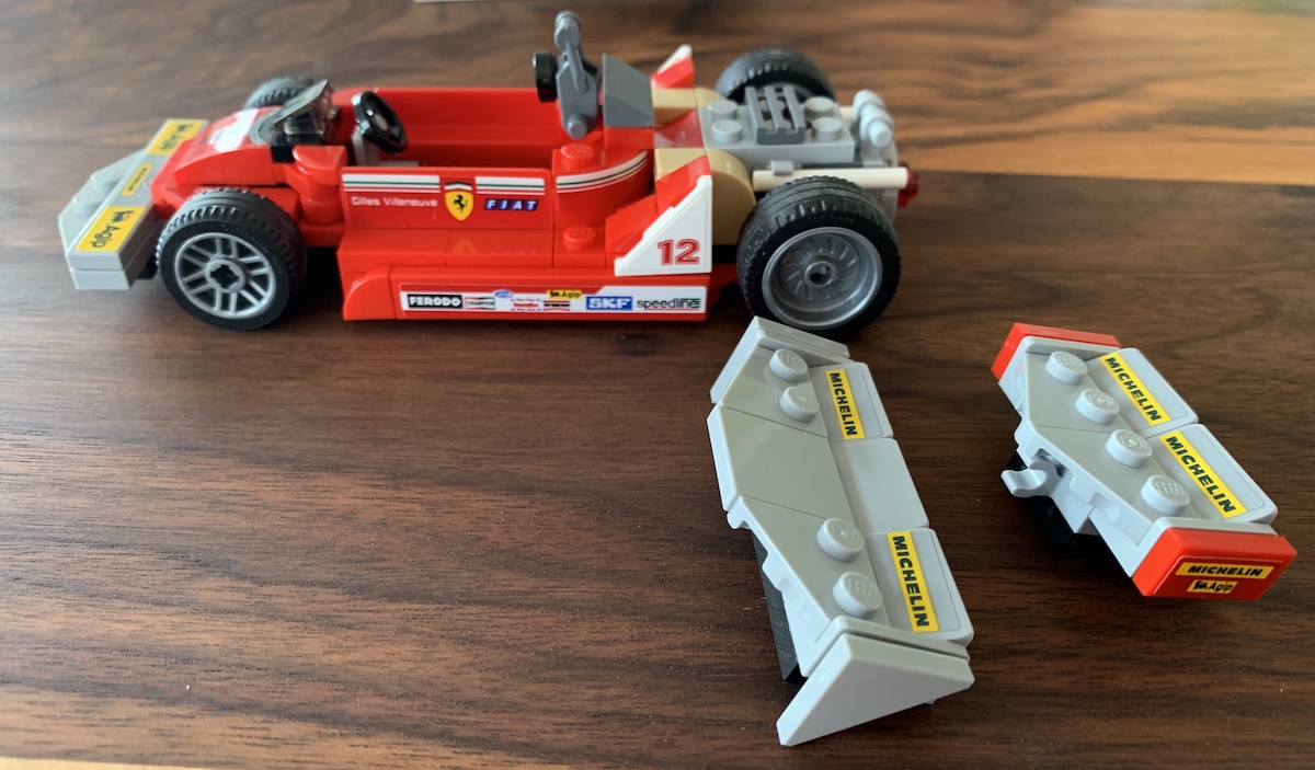 The Ferrari 312 T4 Formula One car as driven in period by Giles Villeneuve. The set comes with two wings, positioned here where they mount on the car for two different looks, the garage wall of the model has space to store both.
